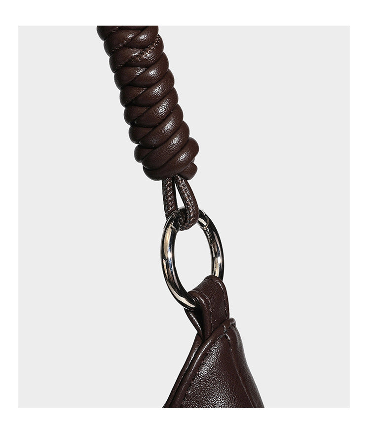 Large slouchy hobo shoulder bag with braided top handle, smooth glossy leather-look finish, and silver-tone ring hardware
