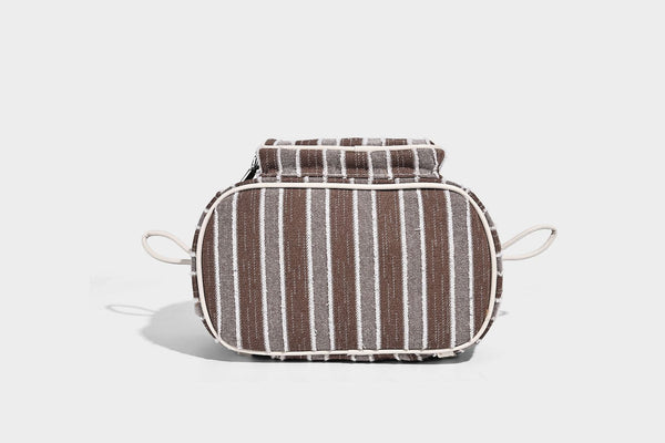Weicher Rucksack aus gewebtem Material mit vertikalen Streifen, Überschlag, Kordelzug, vorderer Reißverschlusstasche, weißen Besätzen und Trägern in Lederoptik, Detailansicht