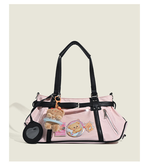 Pale pink nylon tote bag with black leather-look trim, double top handles, side zip pocket, and detachable crossbody strap