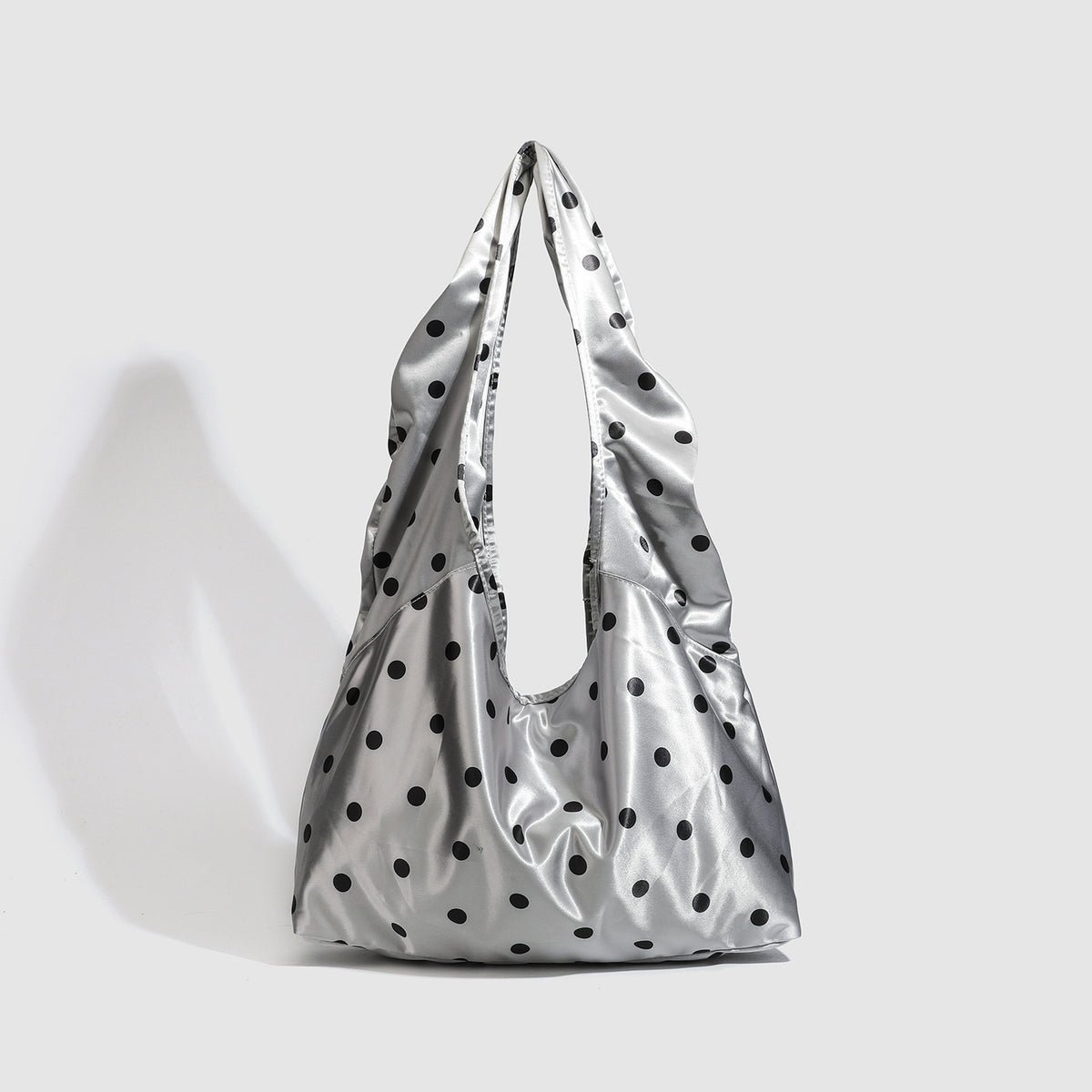 Ovale Tote-Schultertasche in silberfarbener Satinoptik mit schwarzem Punkteprint, Druckverschluss und langen integrierten Trägern, Detailansicht 3
