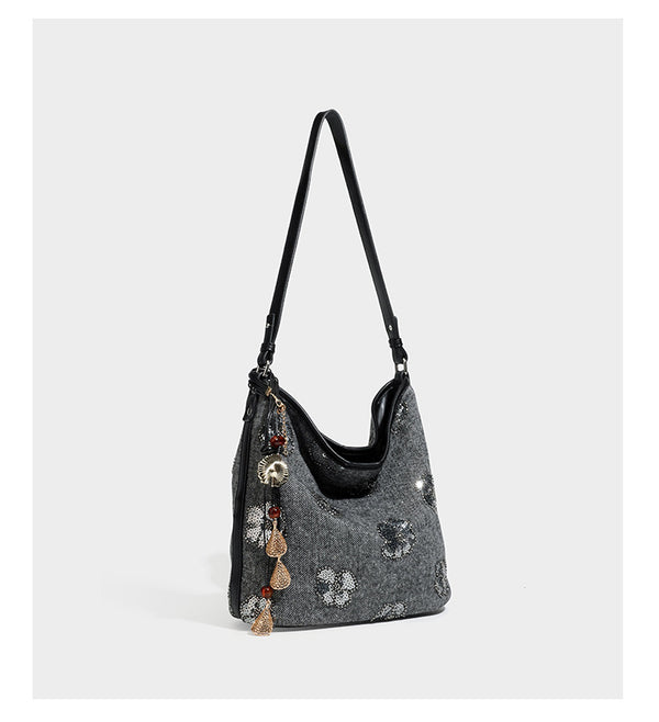 Lässig fallende Hobo-Schultertasche aus anthrazitfarbenem Webstoff mit floraler Stickerei aus silberfarbenen Pailletten, schwarzem Besatz in Lederoptik und langem
