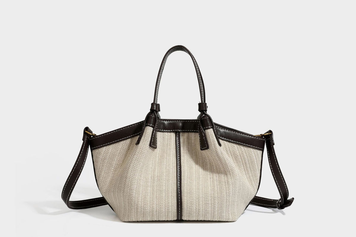 Cremefarbene geflochtene Tote-Bag mit dunkelbraunen Besätzen in Lederoptik, kontrastierenden weißen Nähten, zwei oberen Henkeln und abnehmbarem Schulter