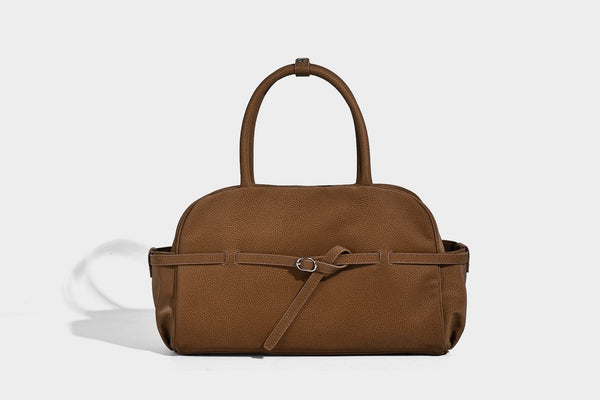 Strukturierte Henkeltasche aus mattem, genarbtem Material mit umlaufendem Riemen und Ringbeschlägen, zwei oberen Tragegriffen und abnehmbarem Crossbody-Riemen
