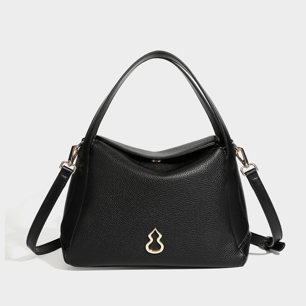 Structured pebbled leather-look shoulder bag with flap top, gold-tone emblem hardware, dual top handles, and detachable