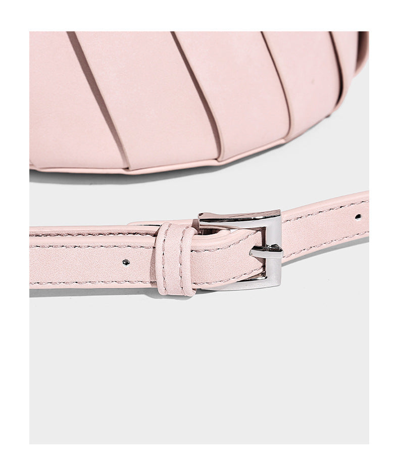 Structured pleated-panel bucket bag with curved top handle and detachable adjustable shoulder strap in smooth matte, detail