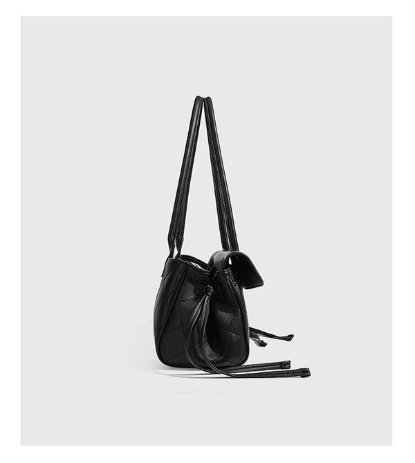 Structured black diamond-quilted shoulder bag with gold-tone turn-lock flap closure and dual round shoulder straps, detail