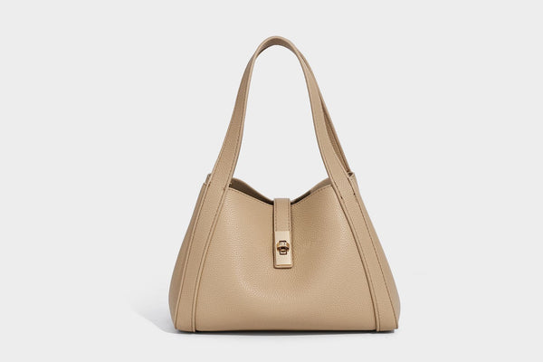 Structured trapezoid tote bag in taupe pebbled leather-look finish with gold-tone turn-lock hardware, dual top handles, and