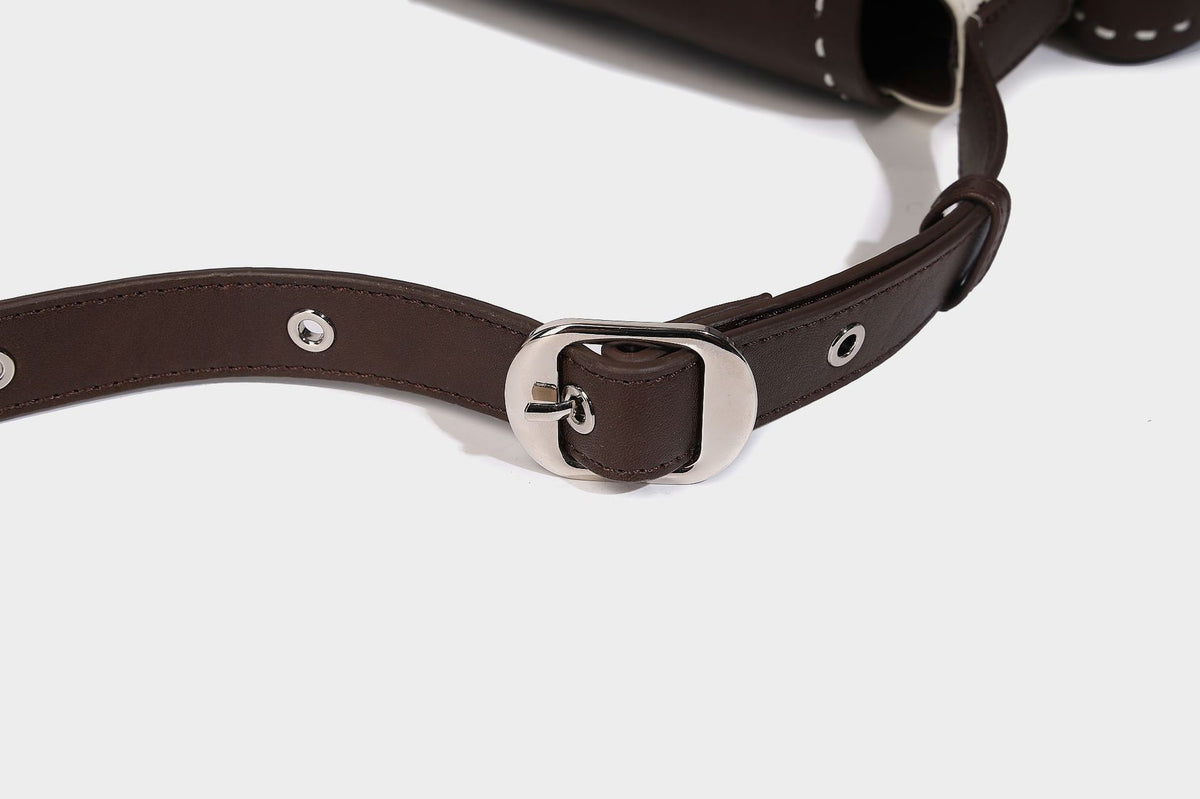Structured flap crossbody bag in dark brown and cream color-block with white contrast stitching, adjustable shoulder strap