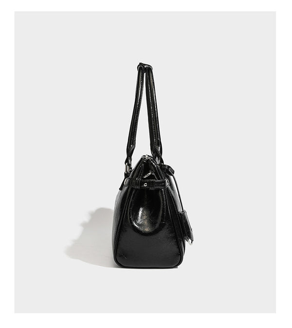 Structured glossy crinkled leather-look satchel with double top handles, front metal-plaque tab, silver-tone hardware, and