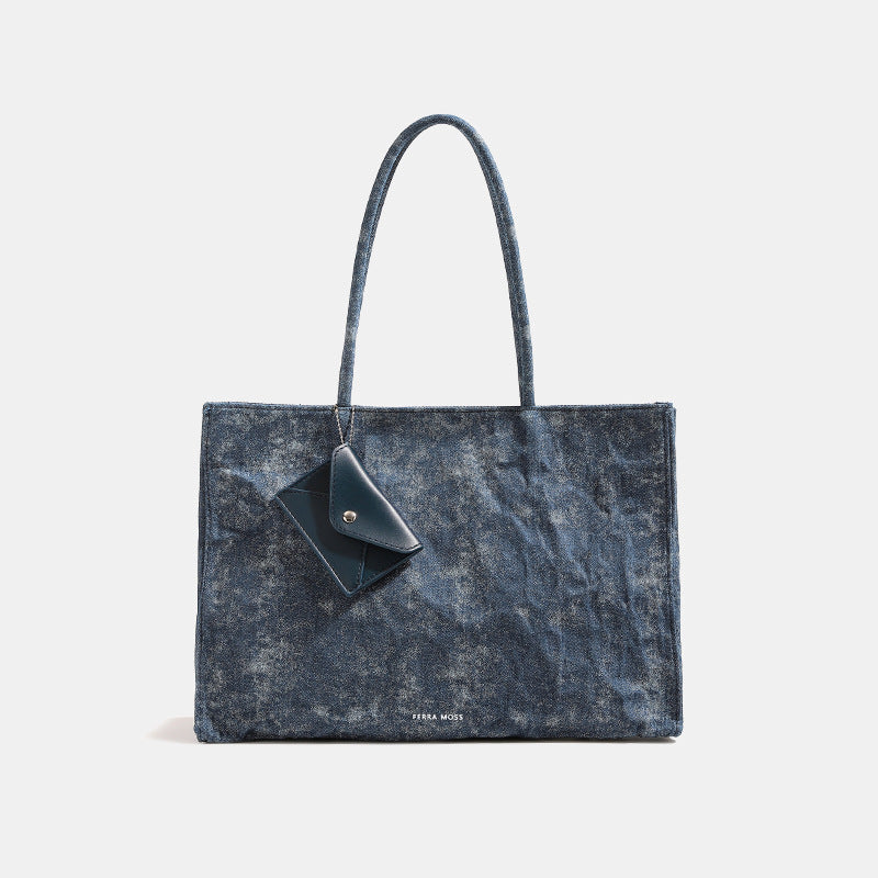 Large glossy crinkled rectangular tote bag with long double handles and hanging envelope snap tag, detail view 8