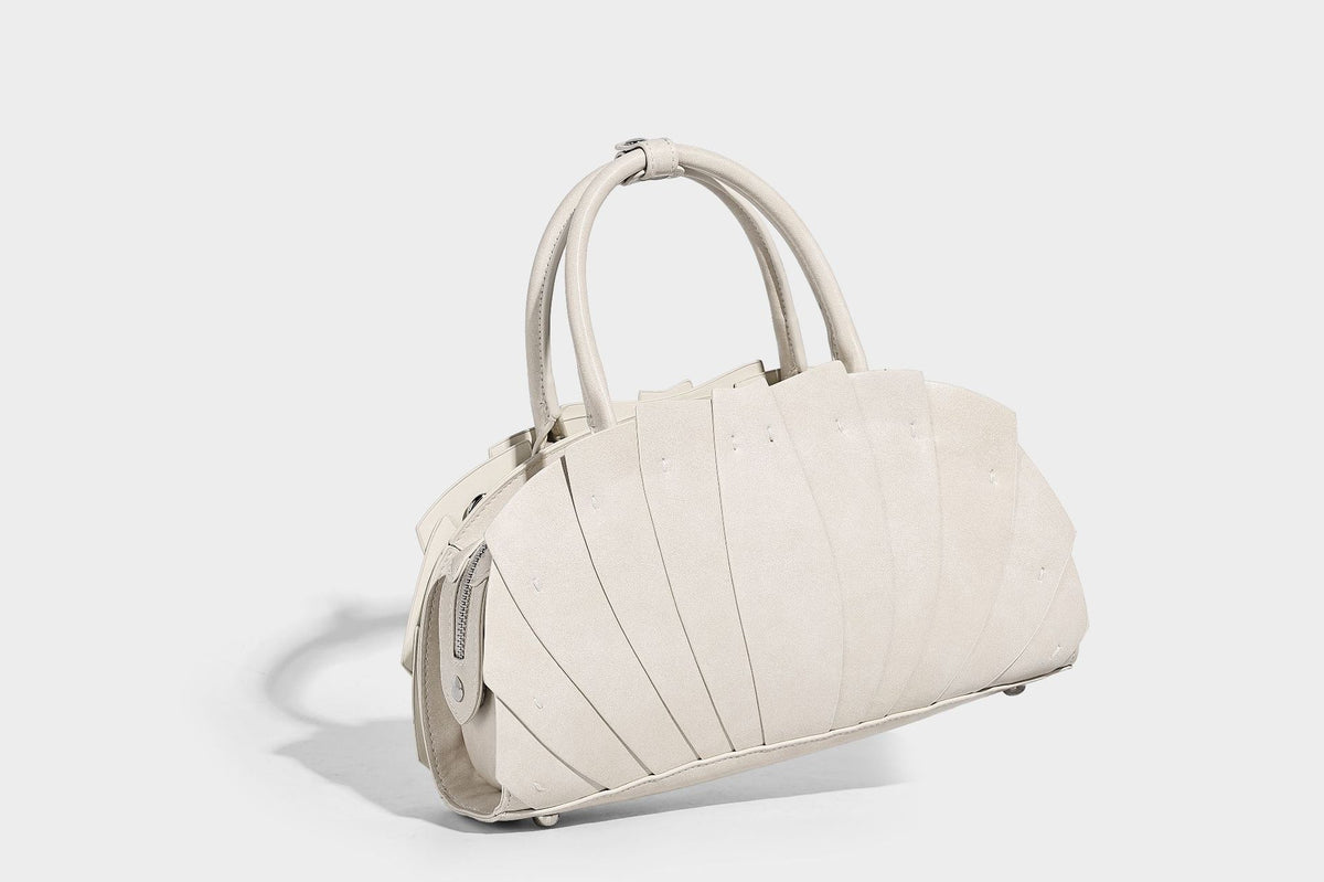 Structured dome satchel with fan-pleated leather-look exterior, dual top handles, and detachable shoulder strap, detail view