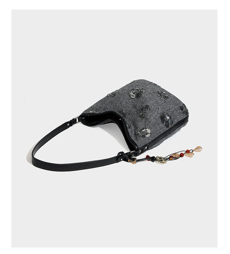 Lässig fallende Hobo-Schultertasche aus anthrazitfarbenem Webstoff mit floraler Stickerei aus silberfarbenen Pailletten, schwarzem Besatz in Lederoptik und langem
