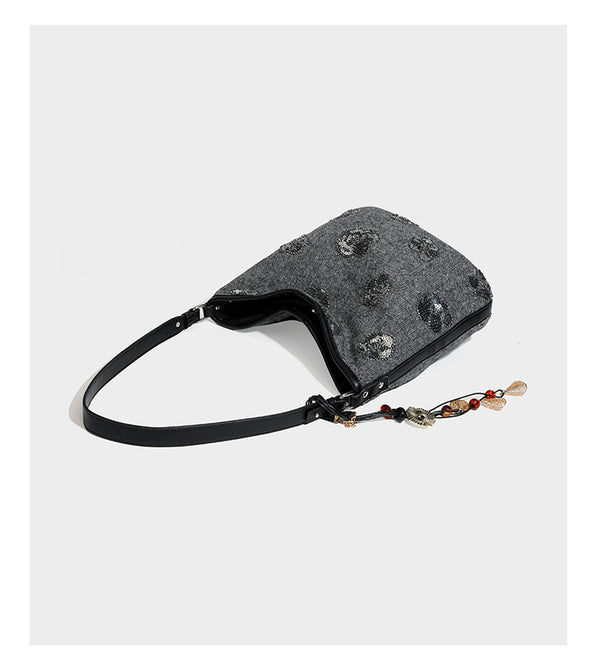 Lässig fallende Hobo-Schultertasche aus anthrazitfarbenem Webstoff mit floraler Stickerei aus silberfarbenen Pailletten, schwarzem Besatz in Lederoptik und langem