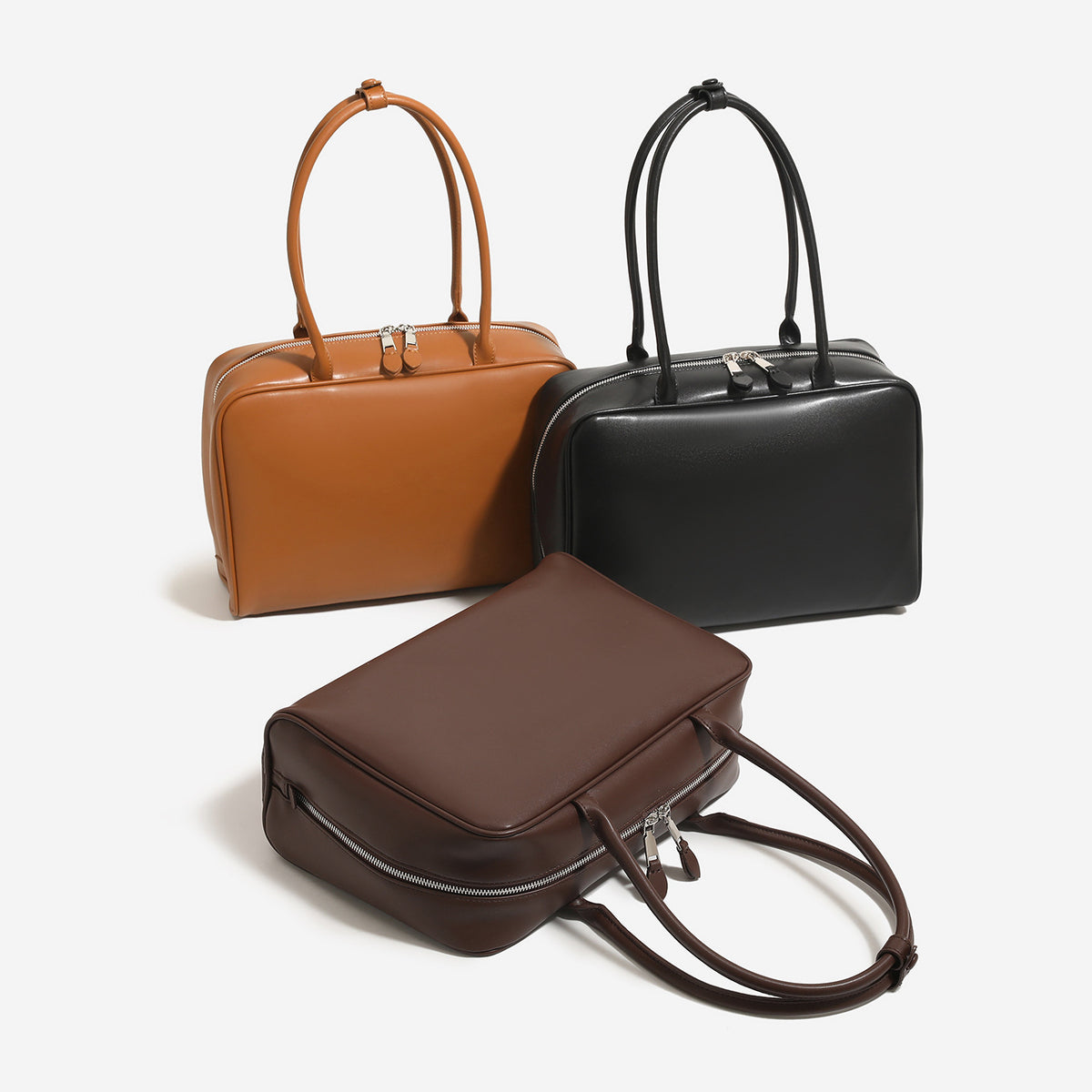 Structured rectangular zip-top tote bag with smooth leather-look finish, dual top handles, and double-zip closure, detail