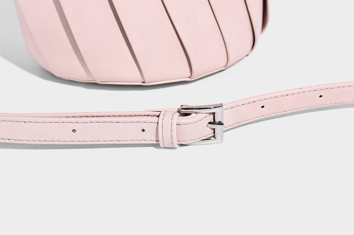 Structured pleated-panel bucket bag with curved top handle and detachable adjustable shoulder strap in smooth matte, detail