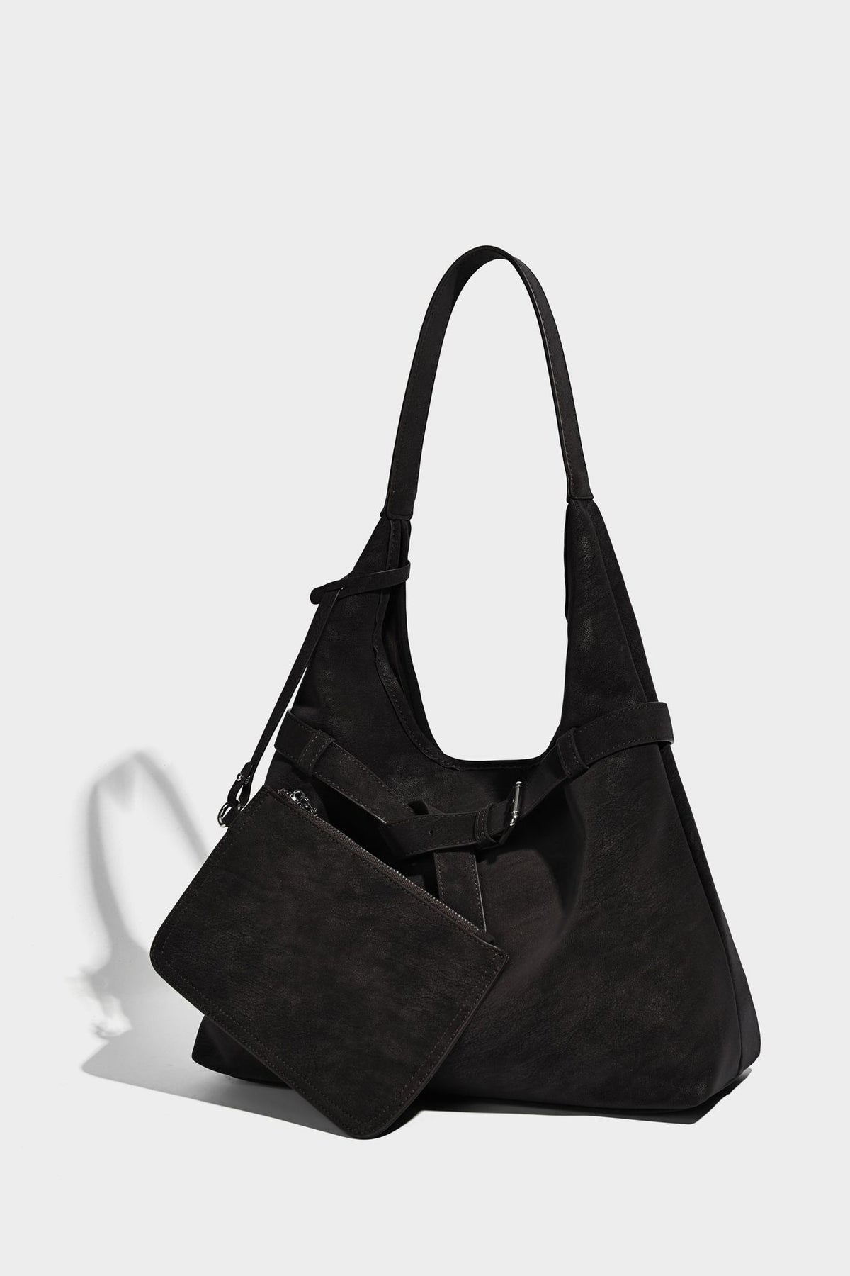 Slouchy oversized shoulder tote bag with matte textured finish, wrap-around buckle strap, and detachable front zip pouch
