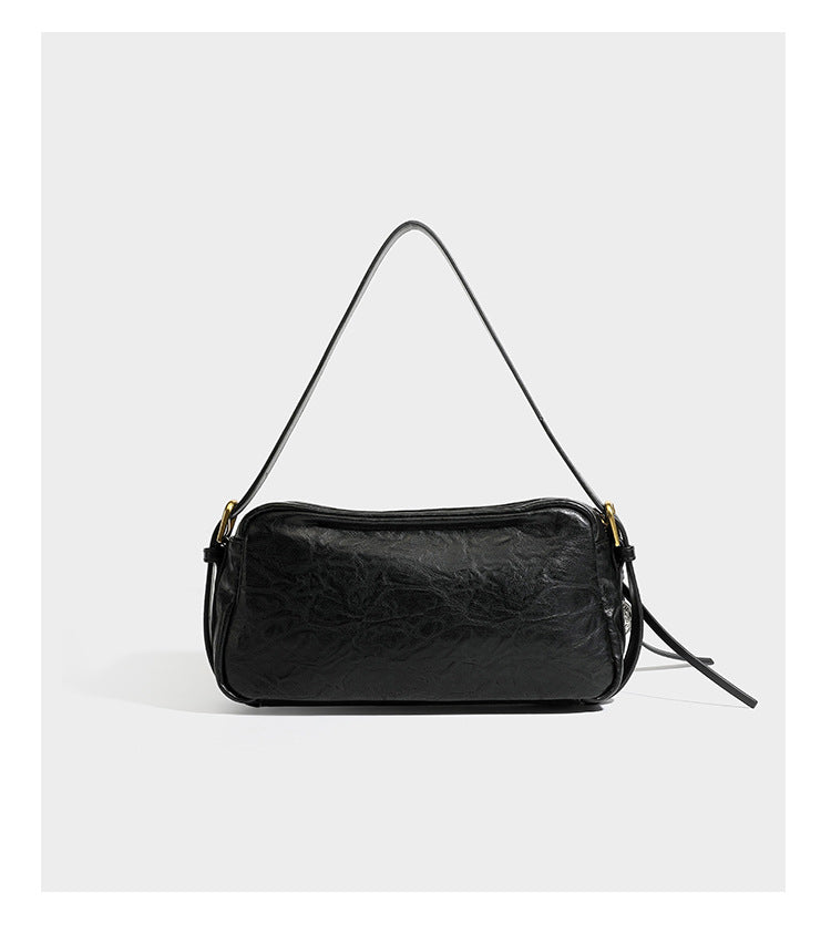 Compact black crinkled leather-look baguette shoulder bag with gold-tone arch hardware and adjustable strap, detail view 10