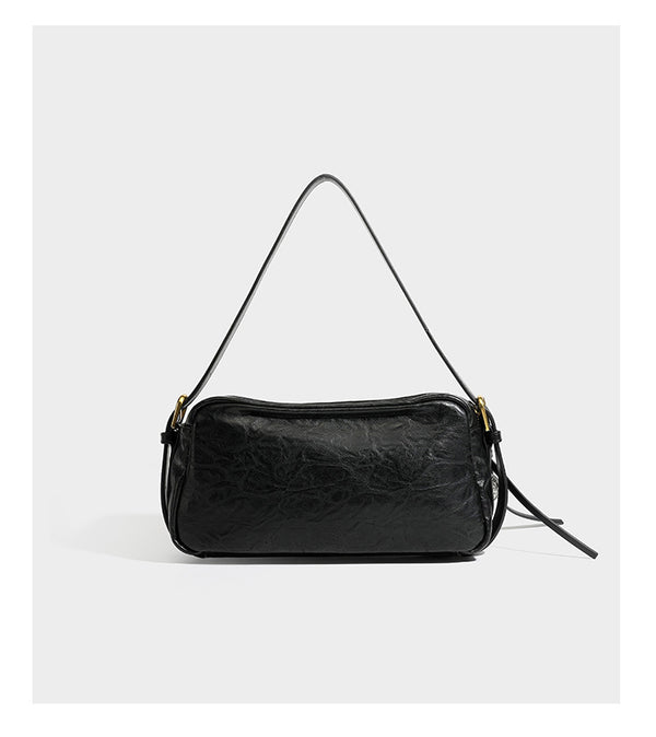 Compact black crinkled leather-look baguette shoulder bag with gold-tone arch hardware and adjustable strap, detail view 10