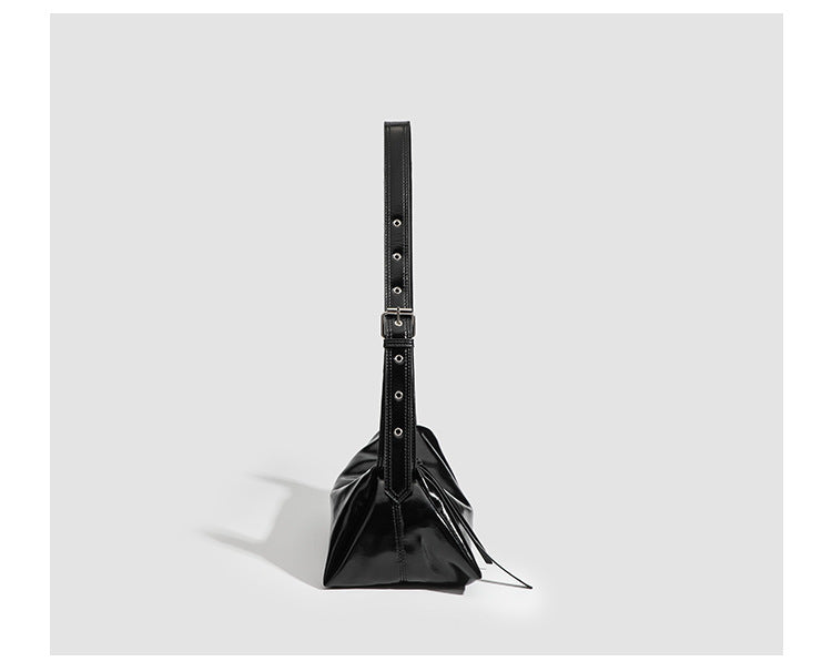 Black glossy leather-look slouchy shoulder bag with gathered top, zip tassel closure, and long adjustable silver-buckle