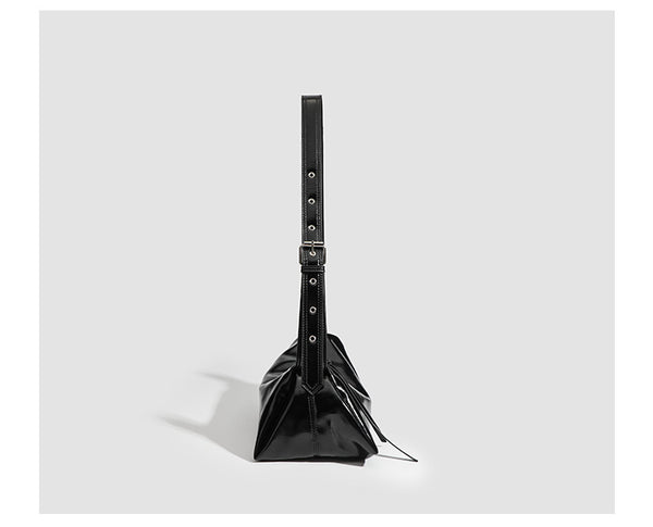 Black glossy leather-look slouchy shoulder bag with gathered top, zip tassel closure, and long adjustable silver-buckle