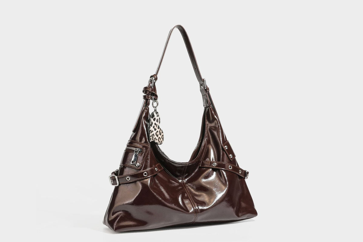 Glänzende dunkelbraune, lässig geschnittene Hobo-Schultertasche mit Riemendetail mit silberfarbenen Ösen, Reißverschlussfach auf der Vorderseite und Herz mit Leopardenmuster