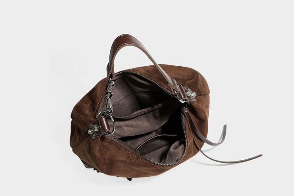 Slouchy suede-finish hobo shoulder bag with dark hardware, exterior zip pocket, tassel ties, and detachable crossbody strap