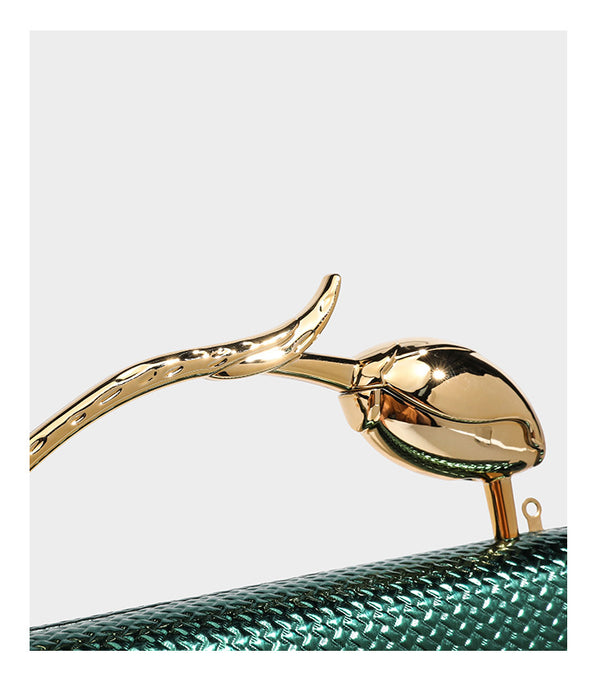 Structured rectangular metallic woven clutch bag with sculptural gold-tone leaf top handle and detachable chain strap, detail