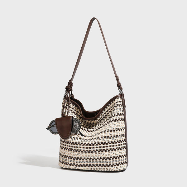 Woven stripe bucket shoulder bag in cream and dark brown with leather-look trim, knotted adjustable strap, and small shield