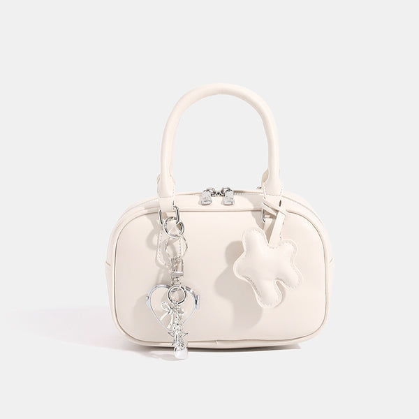 Small structured rounded-rectangle mini handbag with glossy leather-look finish, top zip closure, silver-tone hardware, and