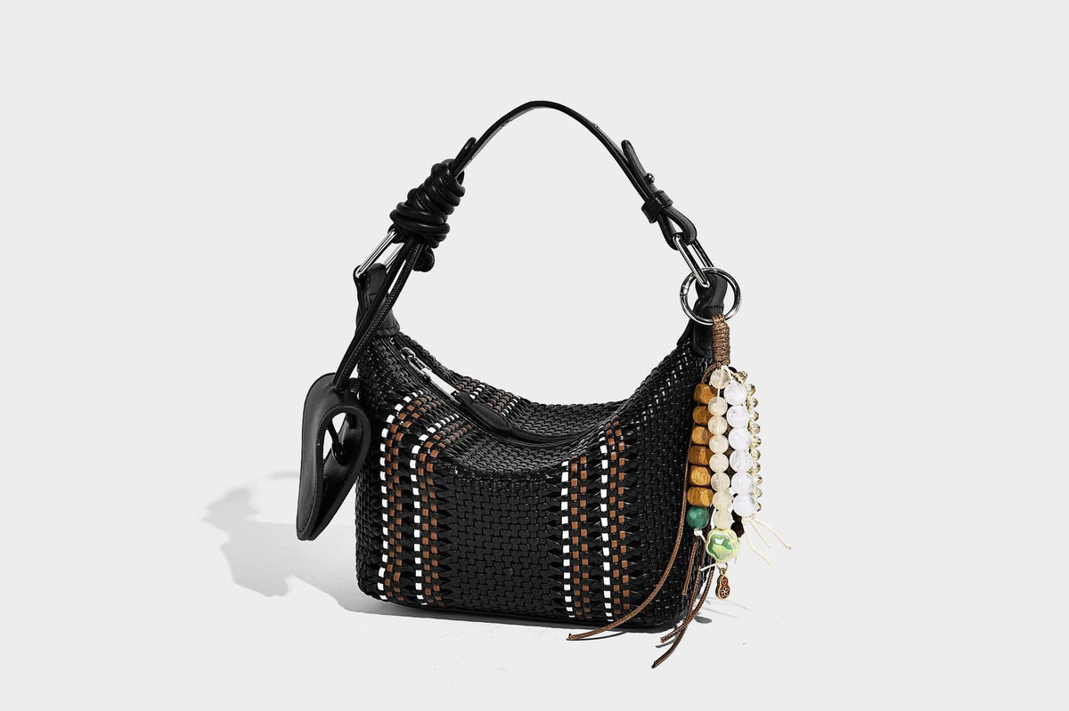 Small woven crescent shoulder bag with leather-look trim, zip closure, silver-tone ring hardware, and beaded tassel charm