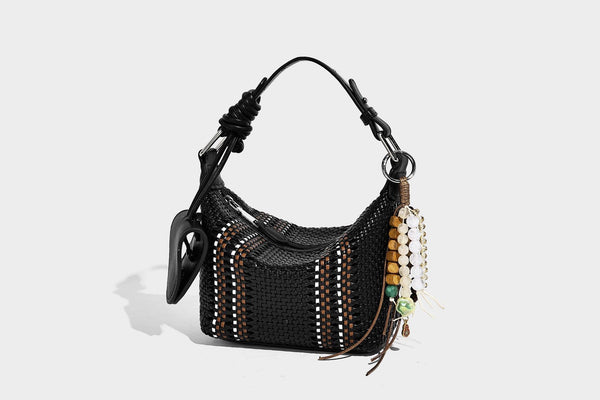 Small woven crescent shoulder bag with leather-look trim, zip closure, silver-tone ring hardware, and beaded tassel charm