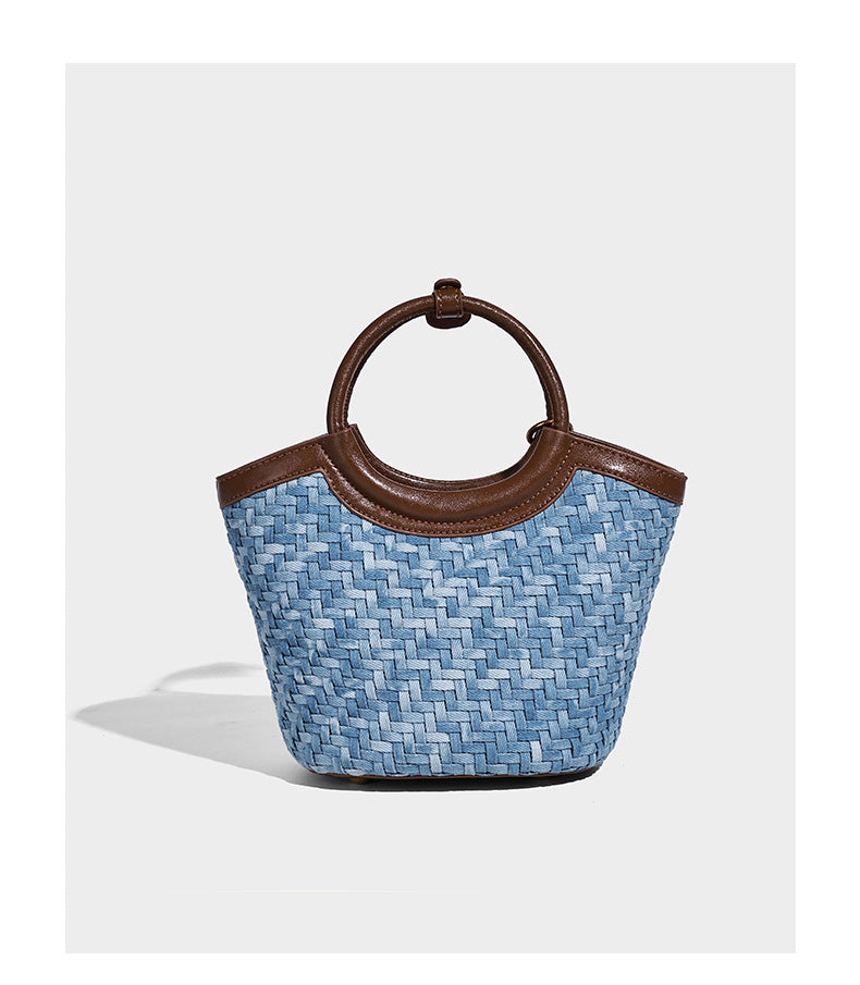 Blaue gewebte Beuteltasche in Denim-Optik mit brauner Besatz in Lederoptik, rundem Tragegriff, Quastenanhänger mit Holzperlen und verstellbarem