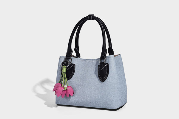 Structured light-blue denim-look tote bag with black leather-look handles, white contrast stitching, silver-tone hardware