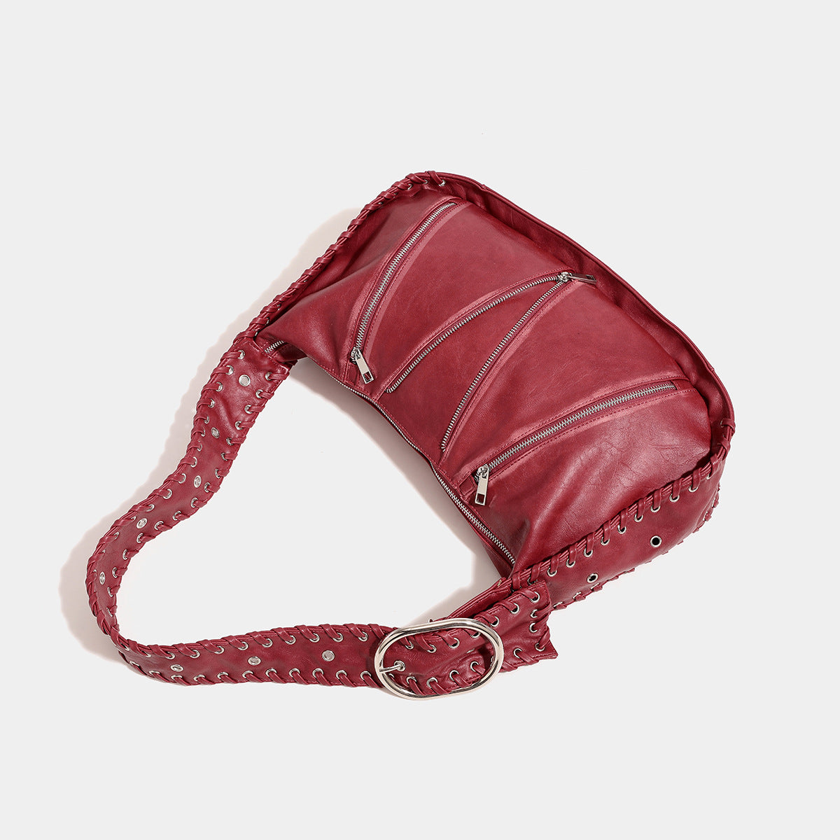 Slouchy hobo shoulder bag with wide braided eyelet strap, multiple front zip compartments, and silver-tone ring buckle