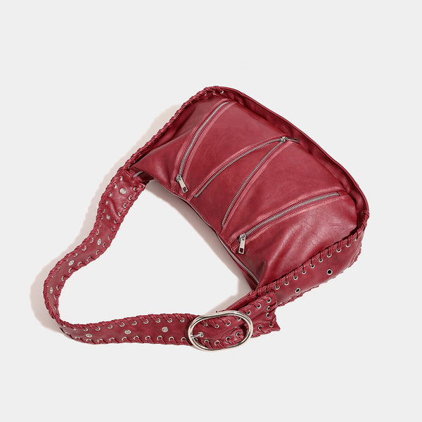 Slouchy hobo shoulder bag with wide braided eyelet strap, multiple front zip compartments, and silver-tone ring buckle