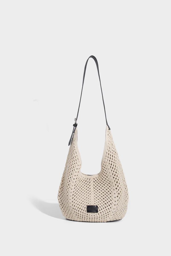Cream openwork crochet hobo bag with black leather-look strap and trim patch accent, slouchy teardrop silhouette, detail view