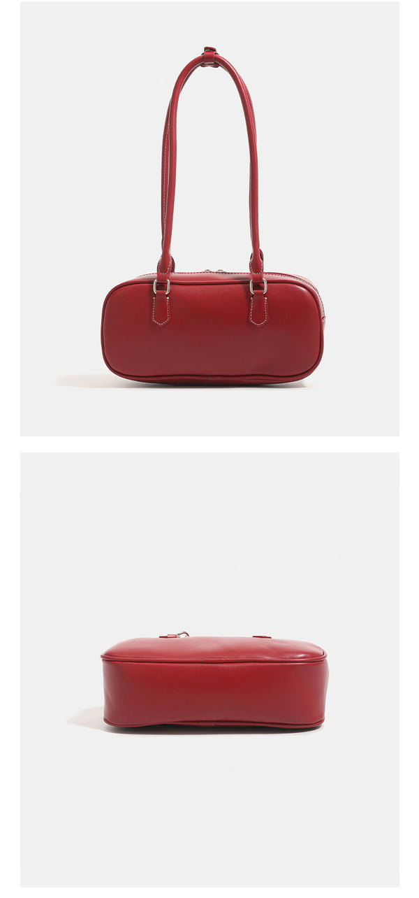 Compact rounded baguette shoulder bag with smooth leather-look finish, slim double straps, silver-tone zipper hardware, and