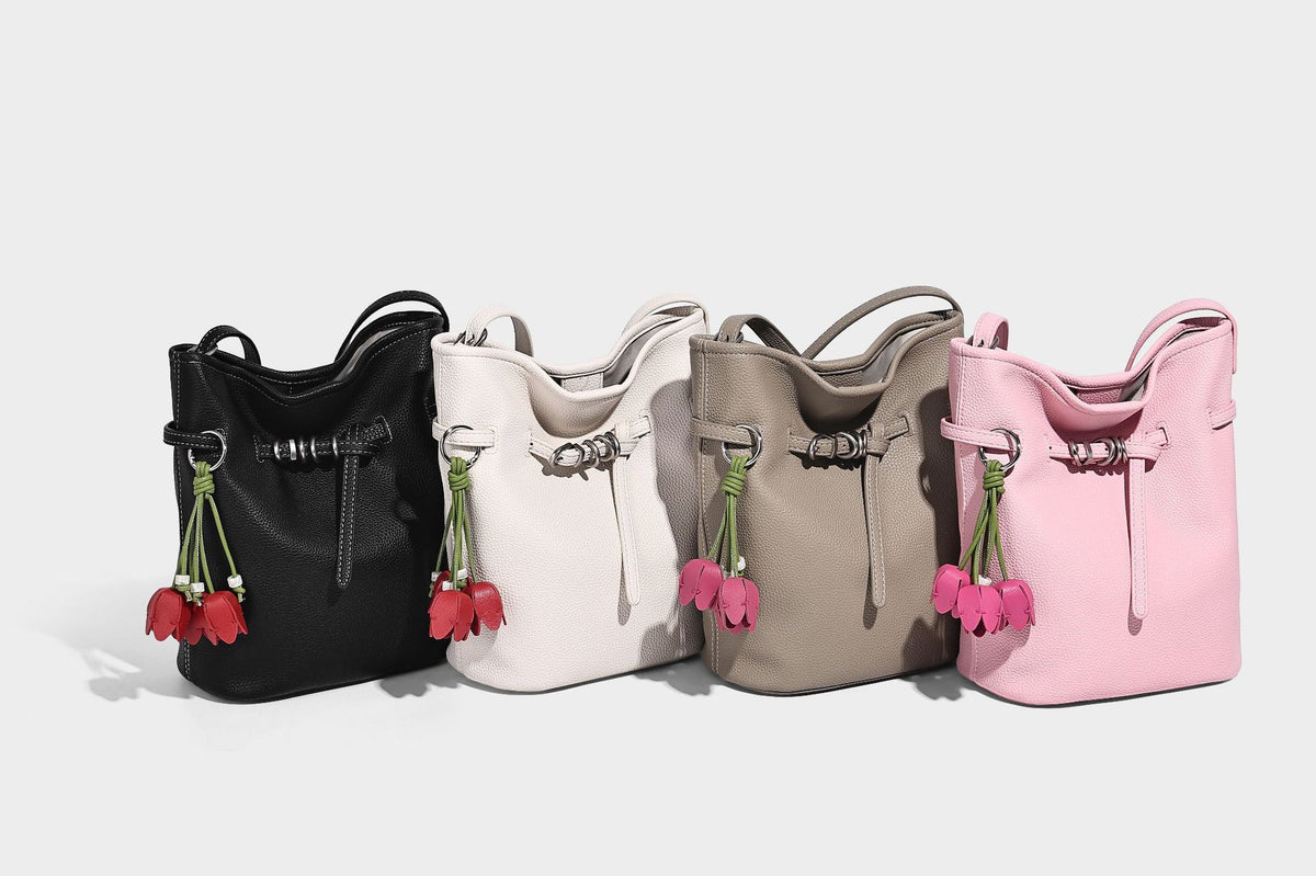 Small pebbled leather-look bucket bag with front drawstring toggle hardware and long adjustable shoulder strap, detail view 9