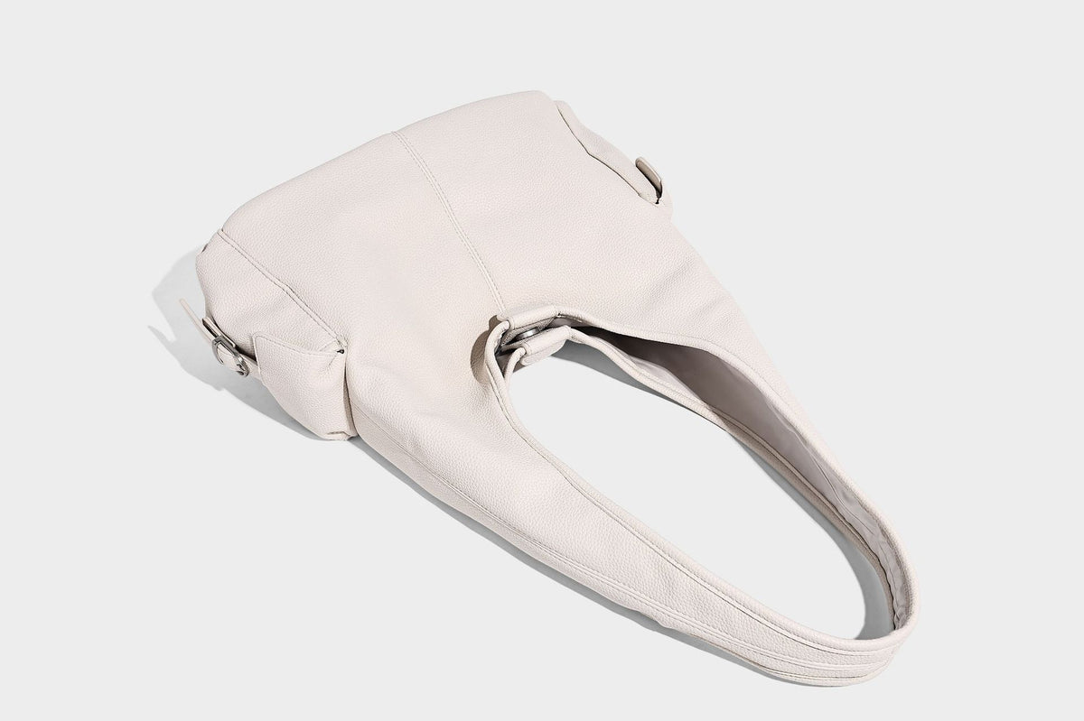 Große, lässig drapierte Hobo-Schultertasche in genarbter Lederoptik mit langem Schulterriemen und seitlicher Klappentasche mit Beschlägen, Detailansicht