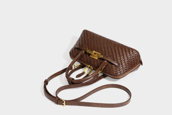 Structured woven-embossed leather-look satchel with dual rolled top handles, gold-tone turn-lock closure, and detachable