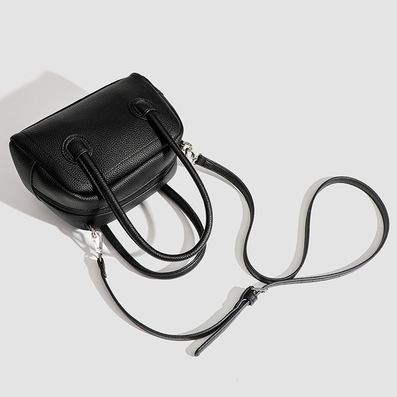 Mini-Boston-Tasche mit genarbter Oberfläche, zwei Tragegriffen, abnehmbarem verstellbarem Crossbody-Riemen und Beschlägen in Silberoptik, Detailansicht