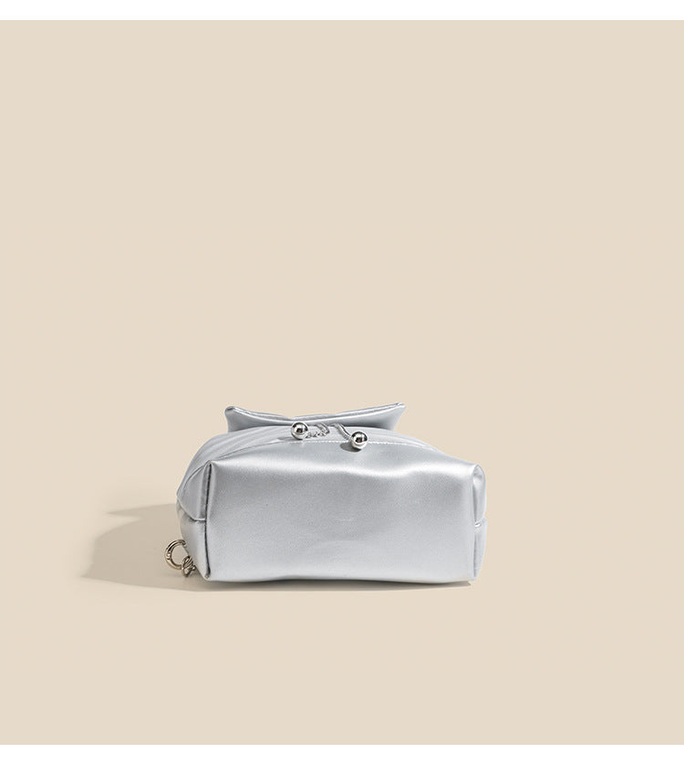 Compact ripple-embossed leather-look backpack handbag with silver butterfly clasp and chain straps, detail view 8