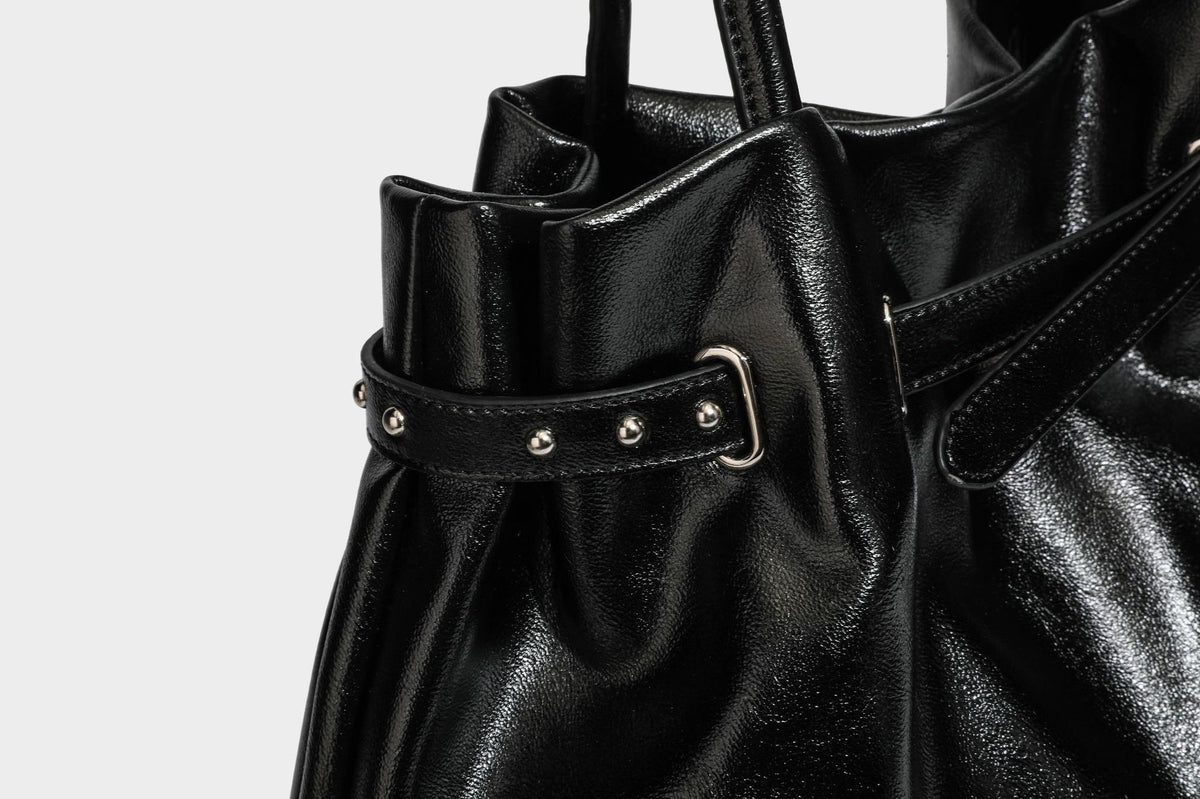 Glänzende schwarze, weich fallende Schultertasche mit gerafftem Abschluss, zwei langen Trageriemen, silberfarbenen Beschlägen und abnehmbarem Umhängeriemen