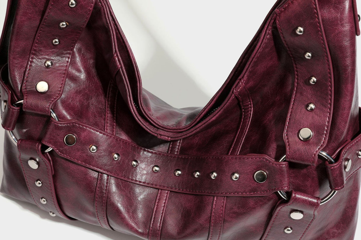 Lässige Hobo-Schultertasche in glänzender Lederoptik mit silberfarbenen Nieten, Riemendetail mit Schnalle und Reißverschluss oben