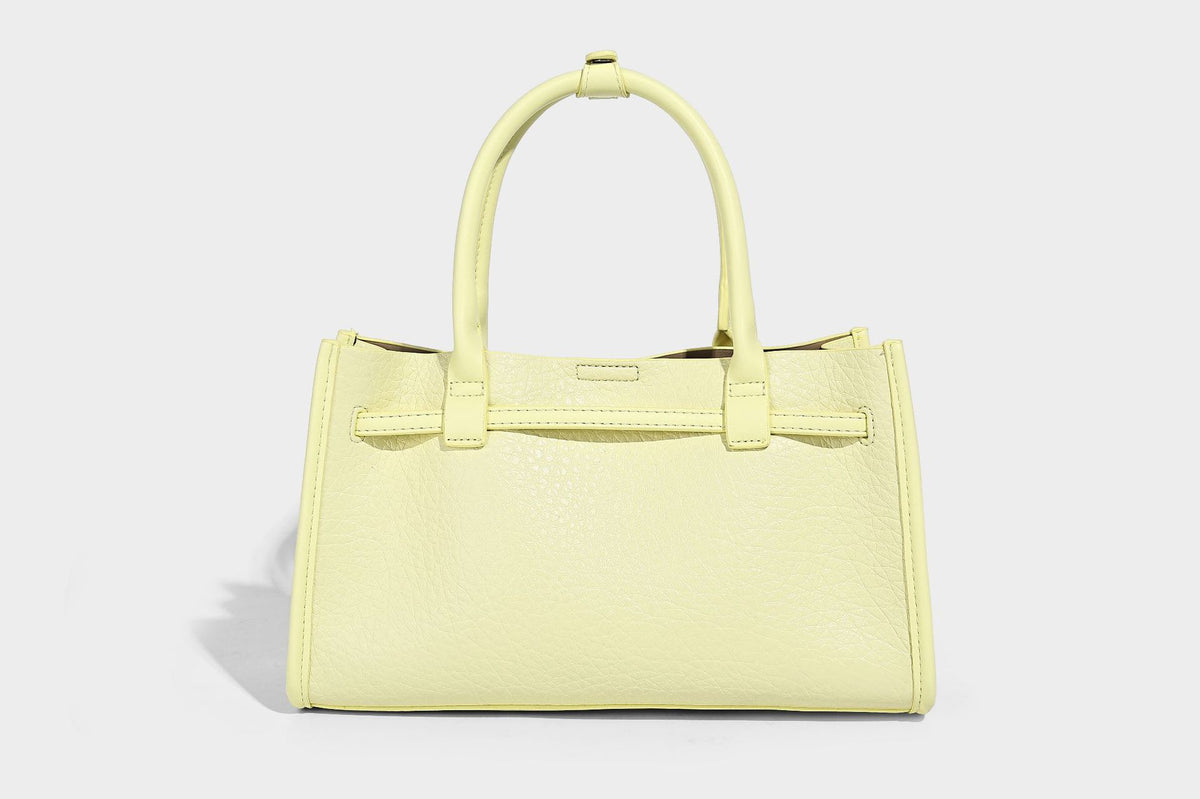 Structured trapezoid tote bag in pebbled leather-look finish with double top handles, silver-tone bar hardware, and, detail