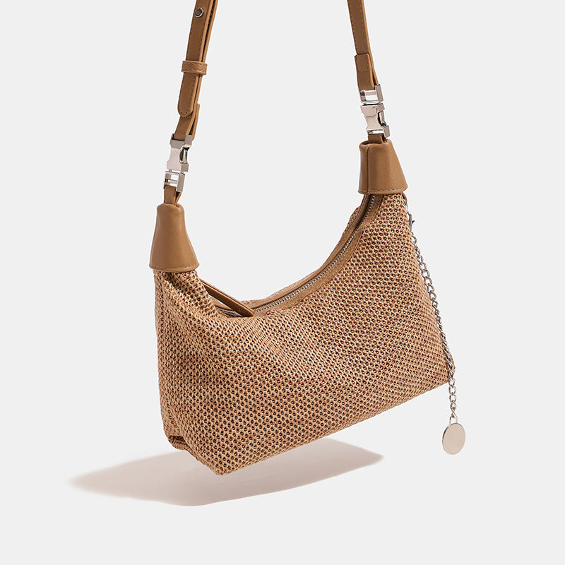 Geflochtene Hobo-Bag aus Stroh mit geknotetem Tragegriff in Lederoptik, silberfarbenen Details und Kettenanhänger in Schwarz und Camel