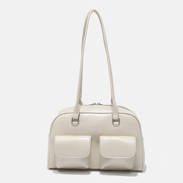 Structured glossy leather-look bowling shoulder bag with two front flap pockets, top zip closure, and long double shoulder