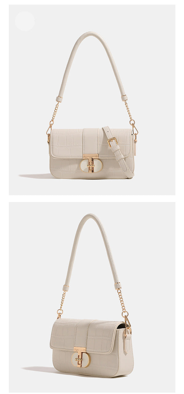 Small structured crocodile-embossed flap shoulder bag with circular gold turn-lock closure and chain-accent strap, detail