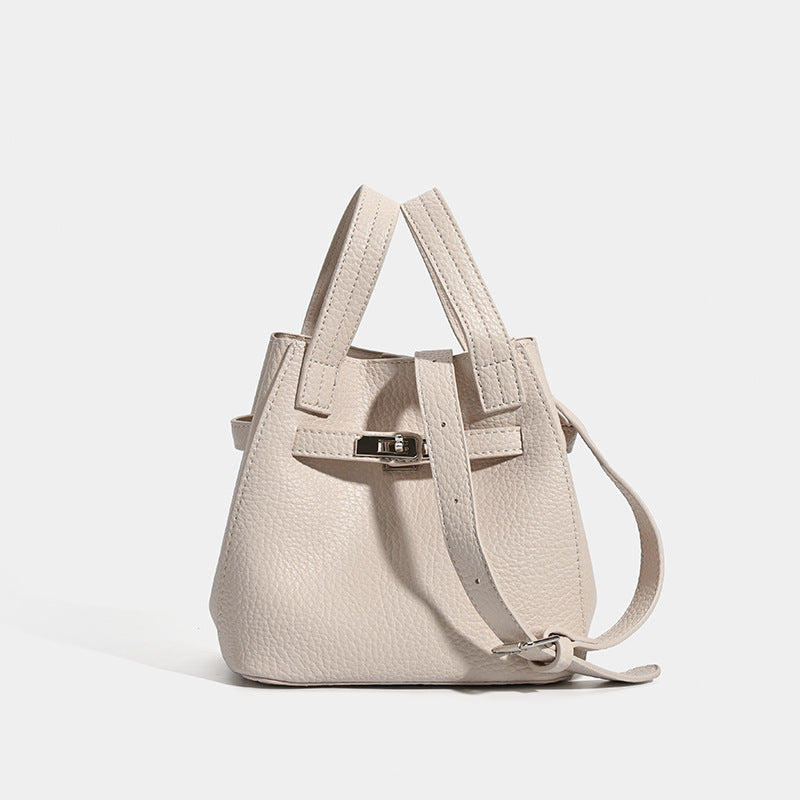 Small structured pebbled leather-look bucket bag with silver turn-lock bar hardware and dual top handles, detail view 7
