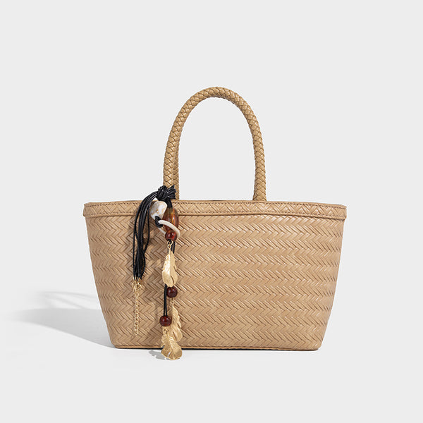 Structured chevron woven leather-look tote bag with braided top handles, gold feather charm, and adjustable shoulder strap